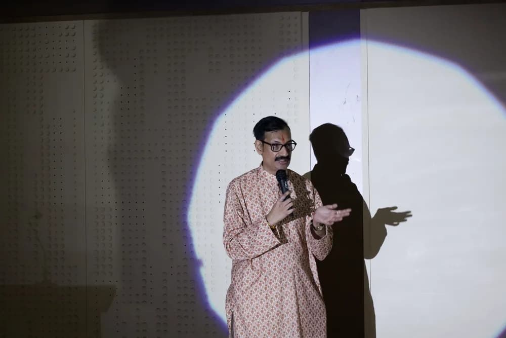 A speaker addressing the audience under a spotlight